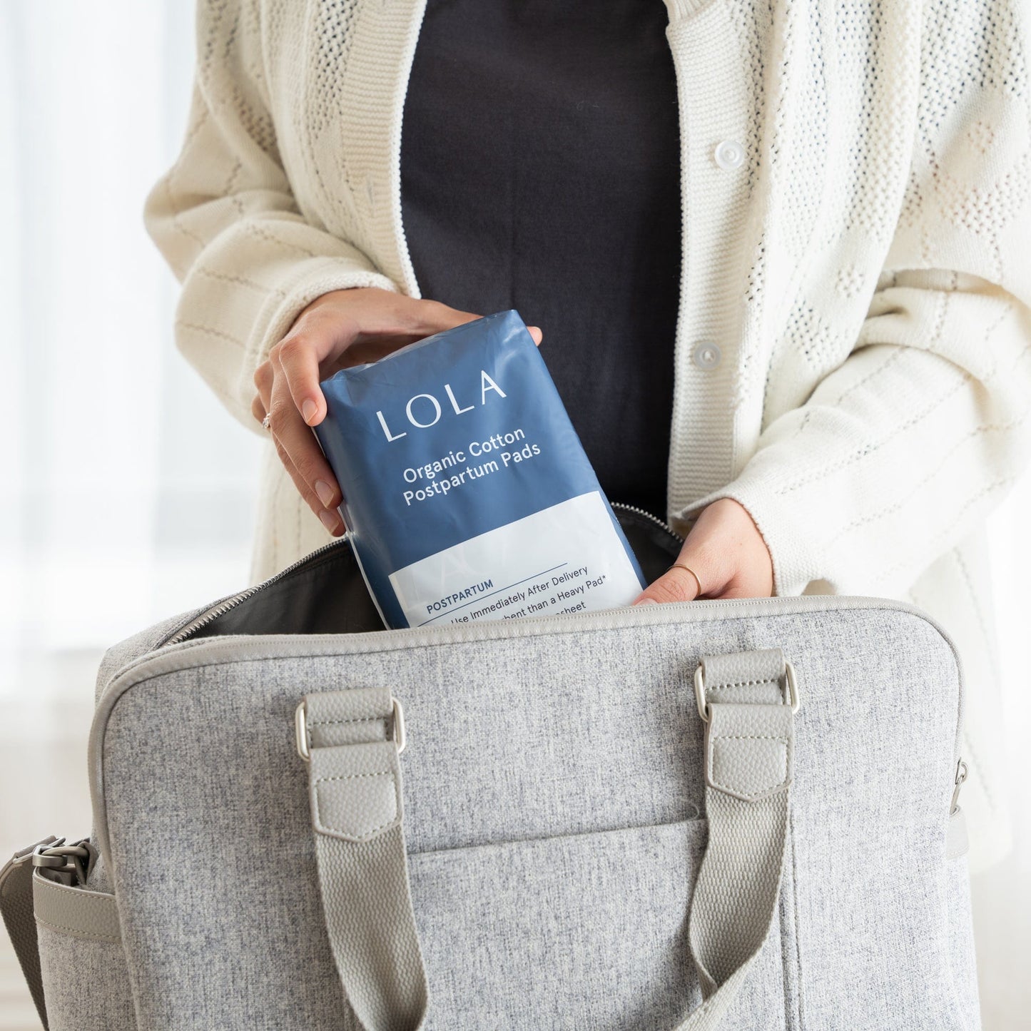 Postpartum pads | Women putting a pack of postpartum pads into her bag