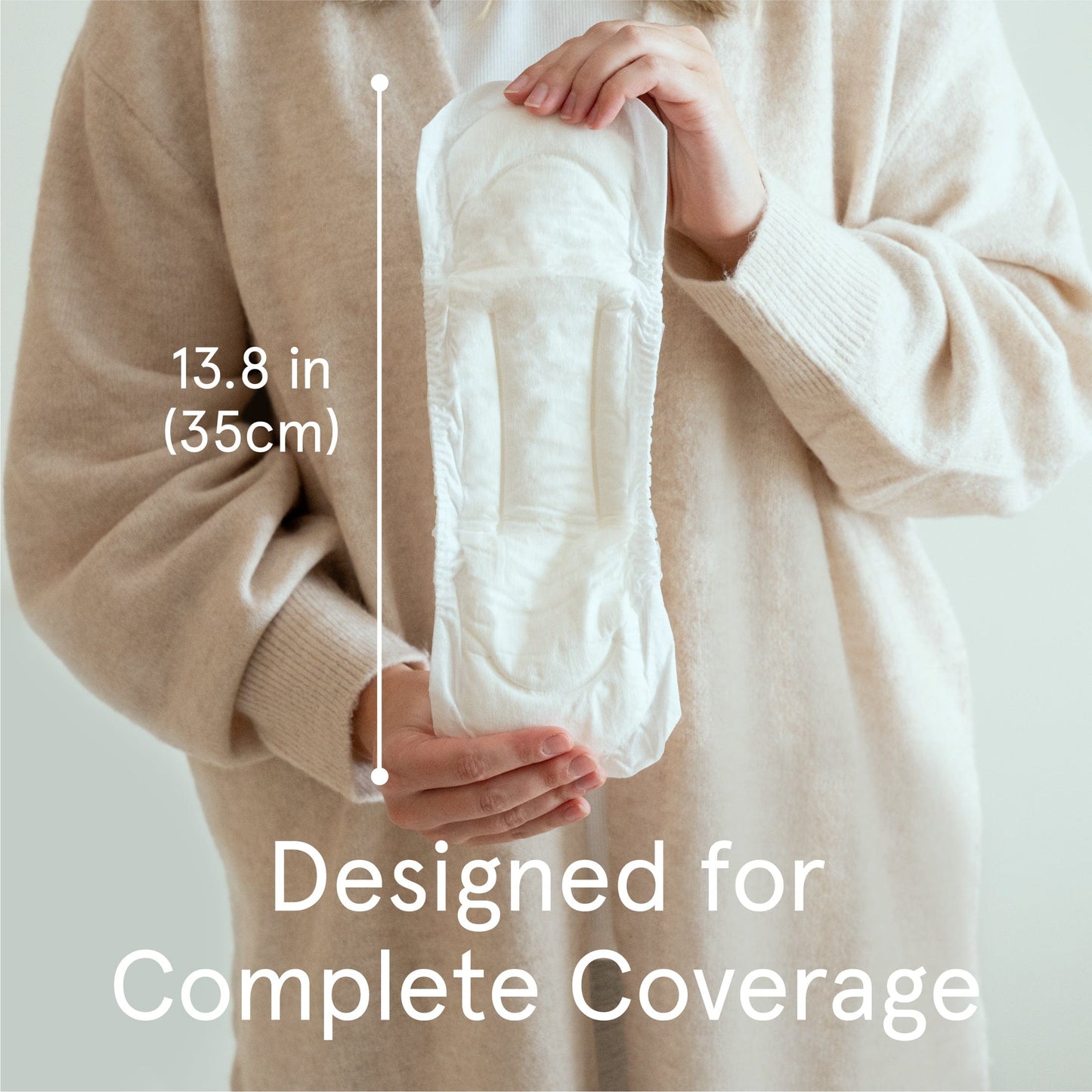 Postpartum pads | Women holding the postpartum pads showcasing the 13.8in length of the pad designed for complete coverage