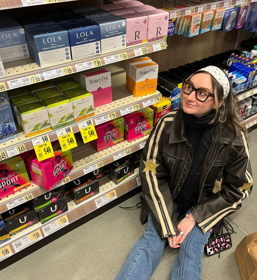 LOLA UGC | Girl sitting in Retail location next to LOLA products in aisle 