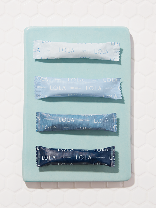 Compact plastic applicator tampons | Front view of four compact tampons on a blue plate